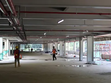 Pekerja tengah menyelesaikan pembagunan gedung parkir di Gelora Bung Karno (GBK) Senayan, Jakarta, Jumat (11/5). Gedung parkir bertingkat itu akan menambah kapasitas sekitar 1.300 kendaraan. (Liputan6.com/Angga Yuniar)
