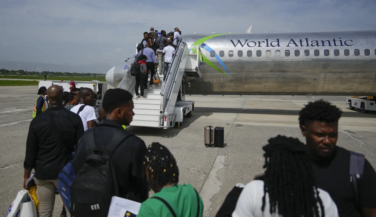 Para penumpang menunggu untuk menaiki pesawat World Atlantic di Bandara Internasional Toussaint Louverture di Port-au-Prince, Haiti, Senin, 20 Mei 2024. (AP Photo/Ramon Espinosa)