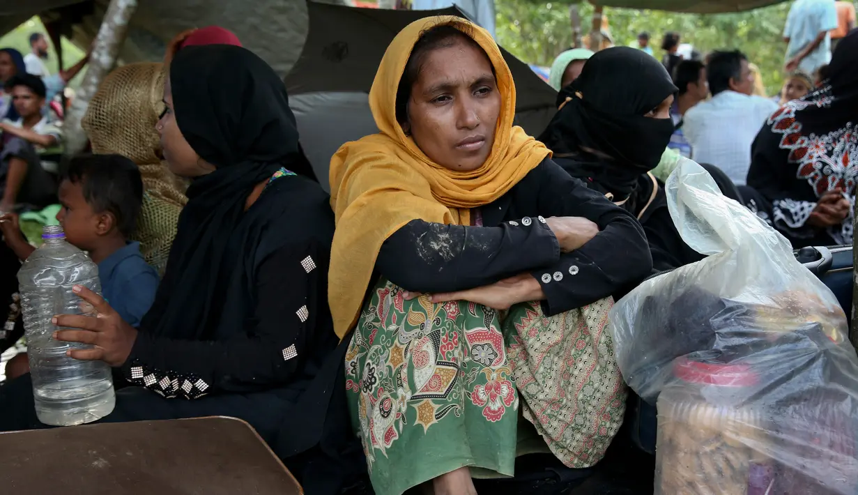 Wanita Rohingya duduk di tempat penampungan darurat di Ghumdhum, Cox's Bazar, Bangladesh, (27/8). Bentrokan tersebut mengakibatkan 92 orang tewas, termasuk 12 tentara. (AP Photo / Mushfiqul Alam)