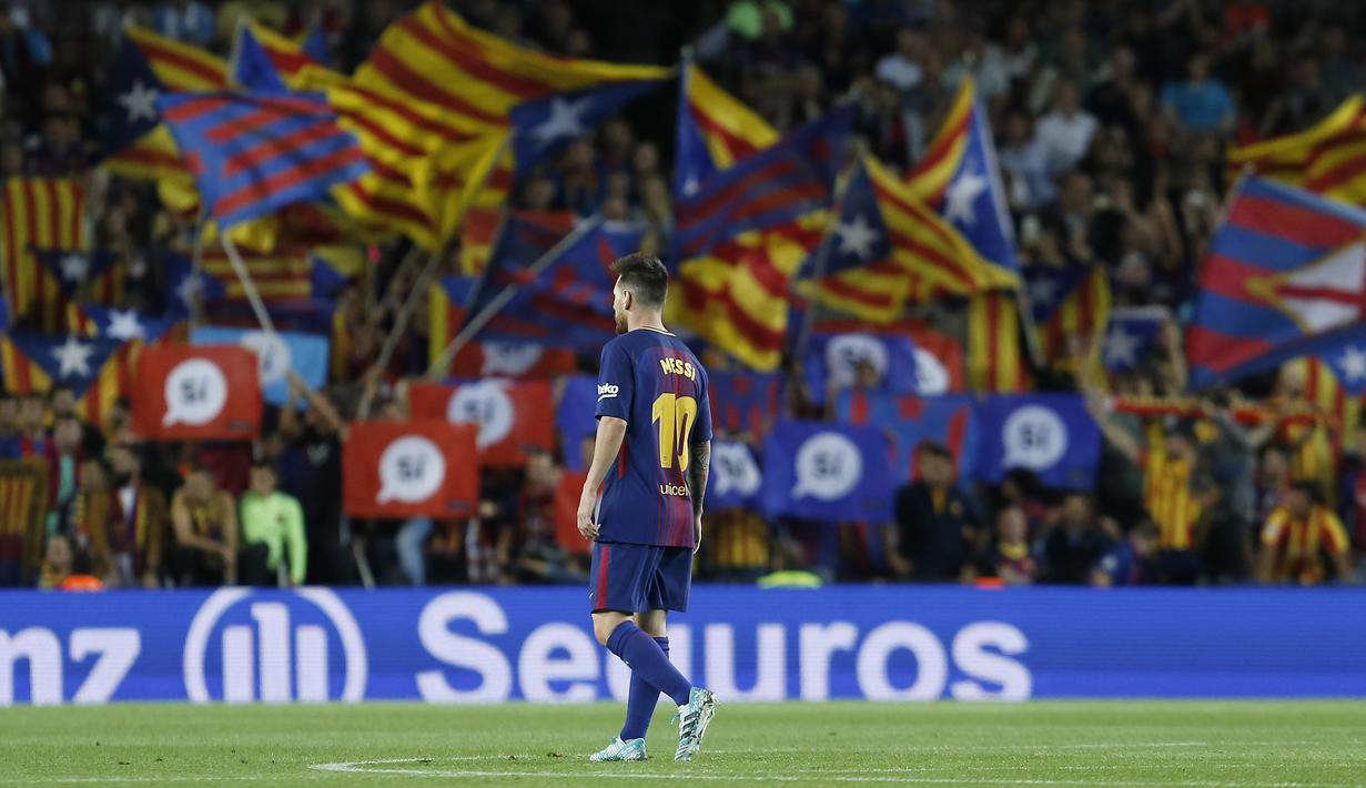 Lionel Messi berjalan menuju ruang ganti dengan latar bendera Catalan usai laga Barcelona melawan Eibar pada lanjutan La Liga Spanyol di Camp Nou stadium, Barcelona (19/9/2017). Barcelona menang 6-1. (AFP/Pau Barrena)