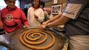 Karyawan memotong-motong donat khas Spanyol atau churros di restoran dessert tradisional La Manueta, Pamplona, Spanyol, Rabu (10/7/2019). Jika dulu hanya dikenal dengan rasa manis setelah digoreng, saat ini churros memiliki topping yang lebih beraneka ragam. (JAIME REINA/AFP)