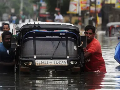 Warga mendorong bajaj saat banjir melanda kawasan mereka di Kaduwela, Kolombo, Sabtu (21/5/2016). Dikabarkan sekitar 80 orang tewas akibat hujan dan tanah longsor yang melanda Sri Lanka. (AFP Photo/Lakruwan W)