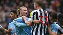 Striker Manchester City, Erling Haaland (kiri) terlibat keributan dengan bek Newcastle United, Dan Burn pada laga lanjutan Liga Inggris 2022/2023 di Etihad Stadium, Manchester, Sabtu (4/3/2023) malam WIB. (AFP/Paul Ellis)