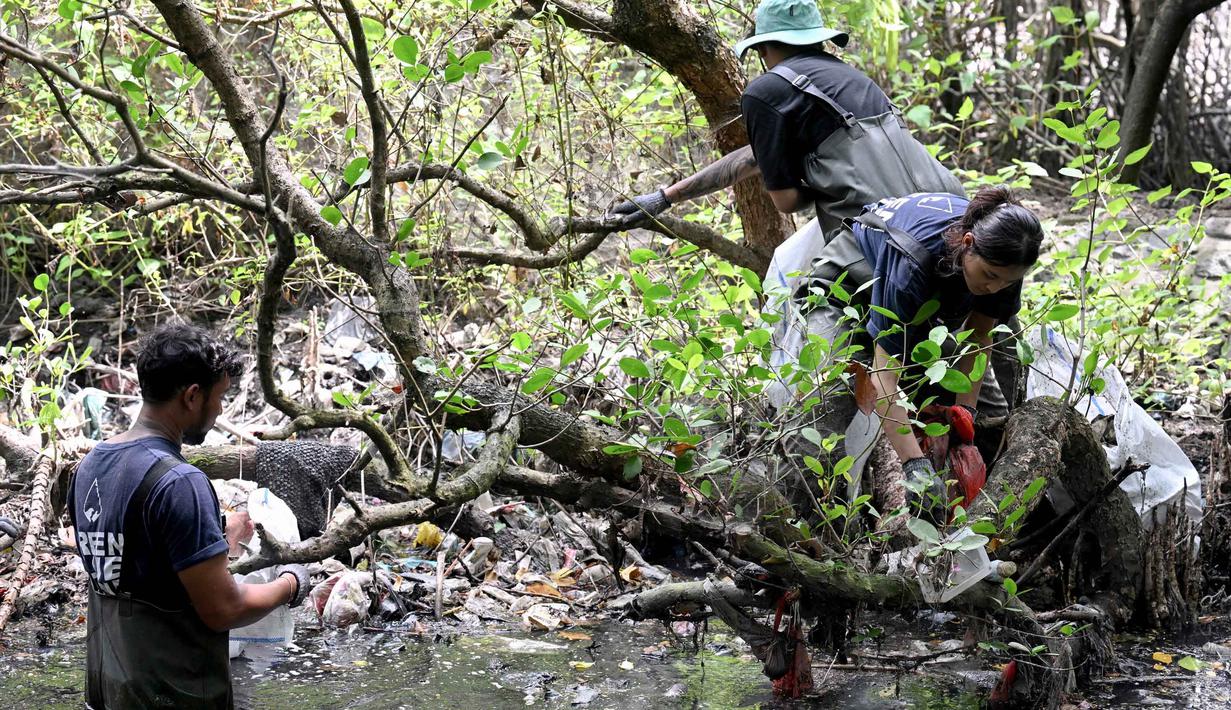 Warga membersihkan sampah plastik di area hutan bakau sebagai bagian dari kampanye kebersihan di Desa Serangan, Denpasar, Bali, pada Rabu 15 April 2026. Sampah plastik yang menumpuk di hutan bakau Desa Serangan, Denpasar, Bali, menjadi ancaman serius bagi ekosistem mangrove. (SONNY TUMBELAKA/AFP)