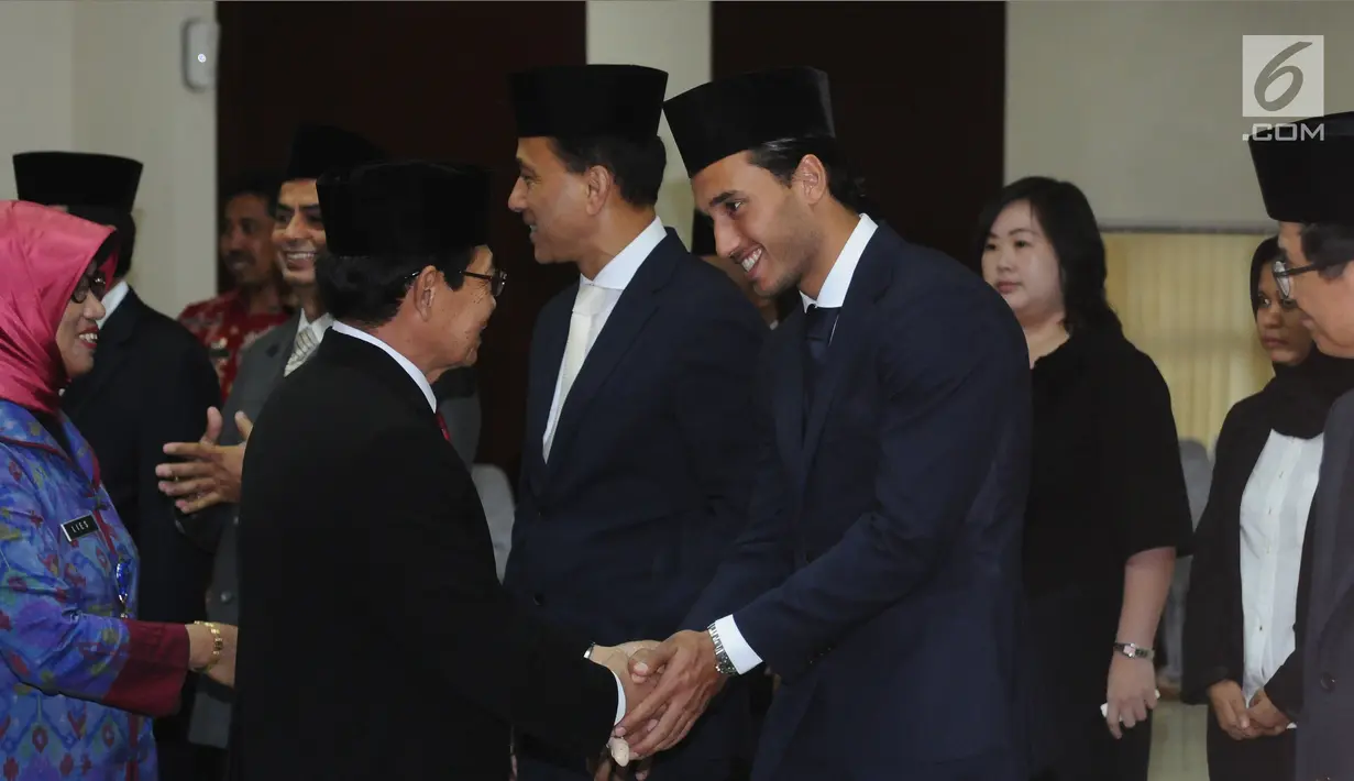 Ketua Kanwil Kemenkumham DKI Jakarta Endang Sudirman menyalami Ezra Walian usai pengambilan sumpah WNI, Kamis (18/5). Resmi jadi WNI, Ezra dijadwalkan bergabung dengan Timnas U-22 di Bali. (Liputan6.com/Helmi Fithriansyah)