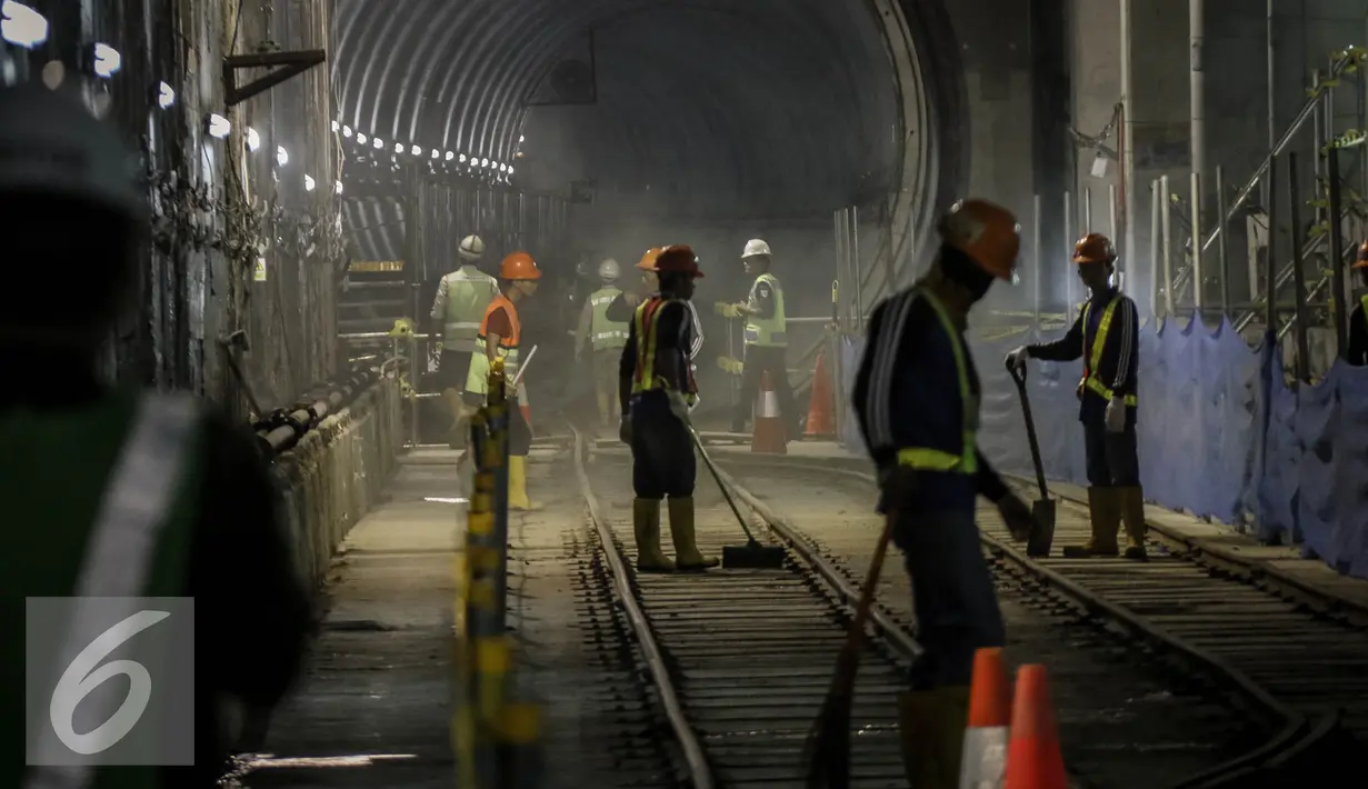 Para pekerja membersihkan jalur rel di terowongan Mass Rapid Transit (MRT) di Dukuh Atas, Jakarta, Jumat (30/9). Jumlah stasiun yang dilalui di rute tersebut sebanyak 13 stasiun. (Liputan6.com/Faizal Fanani)