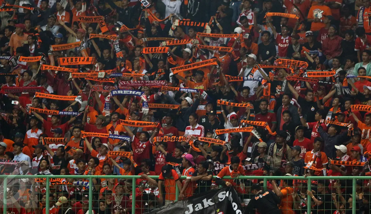 Suporter membentangkan syal saat menyaksikan laga Persija melawan Timnas Indonesia U-22 di Stadion Patriot Candrabhaga, Bekasi, Rabu (5/4). Laga Persija melawan Timnas Indonesia U-22 berakhir imbang 0-0. (Liputan6.com/Helmi Fithriansyah)