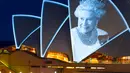 Layar Opera House, landmark ikonik Australia, menyala dengan potret Ratu Elizebeth II di Sydney, Jumat (9/9/2022). Ratu Elizabeth II meninggal dunia pada Kamis 8 September 2022 setelah 70 tahun bertahta. Ia mengembuskan napas terakhirnya di usia 96 tahun. (Photo by Robert WALLACE / AFP)