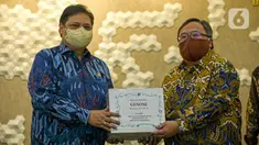 Menristek Bambang Brodjonegoro (kanan) memberikan GeNose C19 kepada Menko Bidang Perekonomian Airlangga Hartarto di Gedung Kemenko Perekonomian, Jakarta, Senin (22/3/2021). GeNose C19 diharapkan dapat semakin dikenal dan dimanfaatkan secara lebih masif. (Liputan6.com/Faizal Fanani)