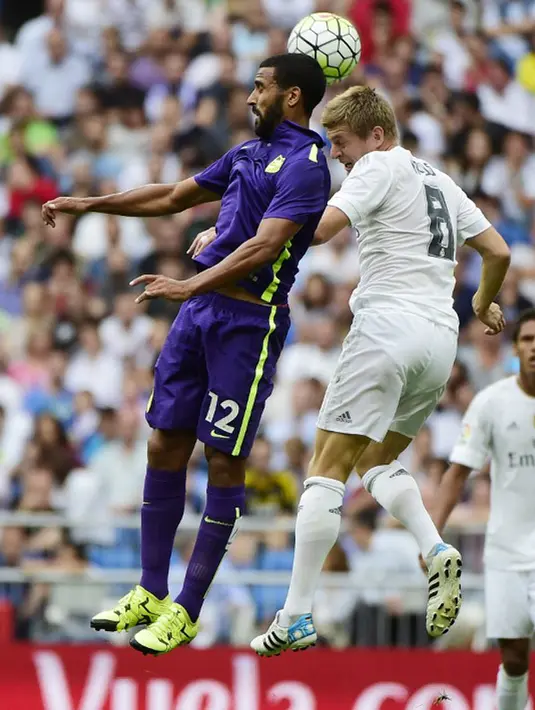 Gelandang Real Madrid, Toni Kroos berebut bola udara dengan gelandang Malaga, Fernando Tissone pada Liga Spanyol di Santiago Bernabeu, Madrid, (26/9/2015). Madrid bermain imbang atas malaga dengan skor 0-0. (AFP PHOTO/PIERRE-PHILIPPE Marcou)