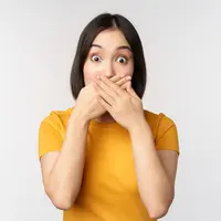 Seorang perempuan menutup mulutnya dengan kedua tangan (Foto Dok: Freepik/benzoix).