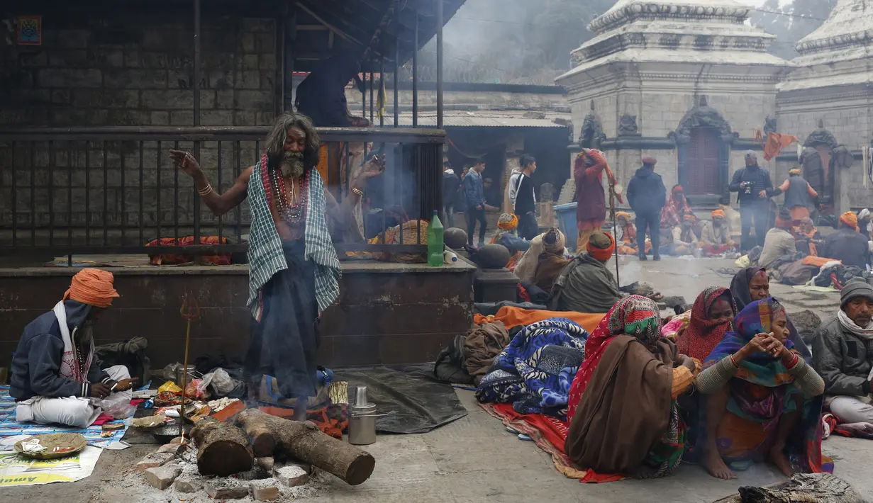 Seorang sadhu (lelaki suci Hindu) meneriakkan slogan dan tarian agama selama festival Shivaratri di lokasi kuil Pashupatinath di Kathmandu, Nepal (20/2/2020). Maha Shivaratri, sebuah festival Hindu yang dirayakan sebelum kedatangan musim semi. (AP/Niranjan Shrestha)