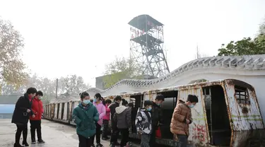 Para wisatawan mengamati gerbong trem di Tambang Wangfeng di Distrik Zhongzhan, Kota Jiaozuo, Provinsi Henan, China tengah (29/11/2020). Tambang Wangfeng yang berlokasi di Distrik Zhongzhan, Kota Jiaozuo, dioperasikan pada 1919 dan memiliki sejarah lebih dari 100 tahun. (Xinhua/Feng Xiaomin)