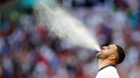 Bek Timnas Inggris, Kyle Walker, menyemburkan air saat pertandingan melawan Denmark pada laga semifinal Euro 2020 di Stadion Wembley, Kamis (8/7/2021). (Foto:AFP/Carl Recine,Pool)
