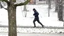 Seorang pria berlari melewati taman bersalju di Nashville, Tennessee, Amerika Serikat, 16 Januari 2022. (AP Photo/Mark Humphrey)