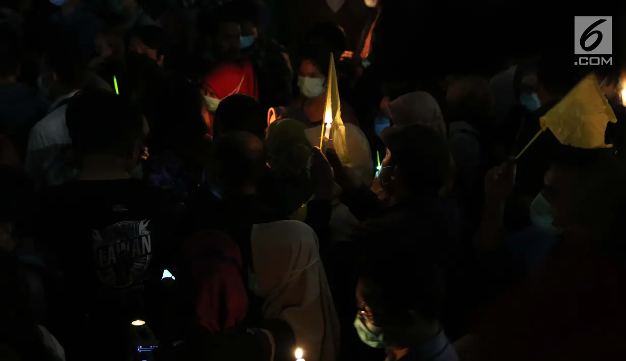 Massa yang tergabung dalam Aliansi Masyarakat Sipil Anti Korupsi menyalakan lilin dan mengibarkan bendera kuning sebagai simbol kematian KPK di depan lobi Gedung KPK, Jakarta, Selasa (17/9/2019). Mereka menilai revisi UU KPK adalah pelemahan institusi tersebut. (Liputan6.com/Helmi Fithriansyah)