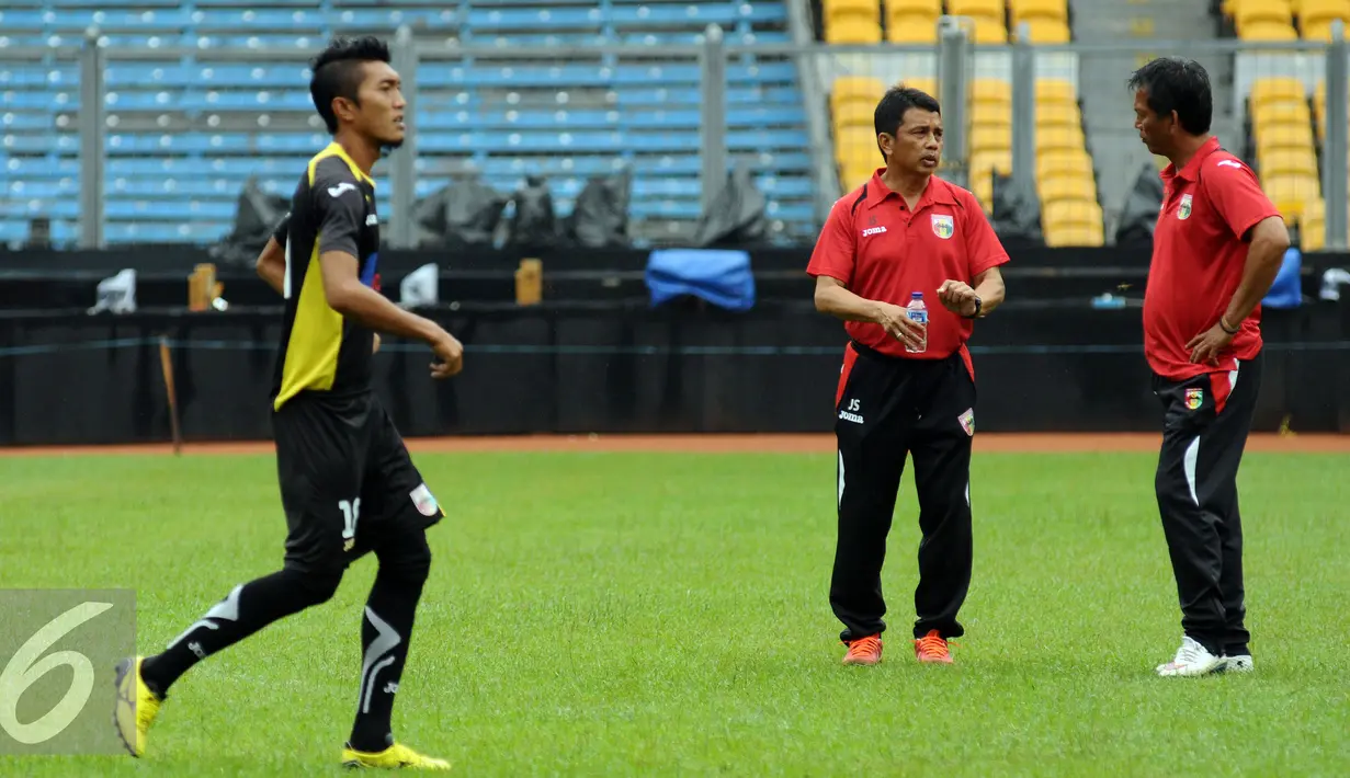 Pelatih Mitra Kukar, Jafri Sastra (tengah) berbincang dengan asistennya saat berlatih di Stadion GBK Jakarta, Sabtu (23/1/2016). Mitra Kukar akan melawan Semen Padang di final Piala Jenderal Sudirman, Minggu (24/1). (Liputan6.com/Helmi Fithriansyah)