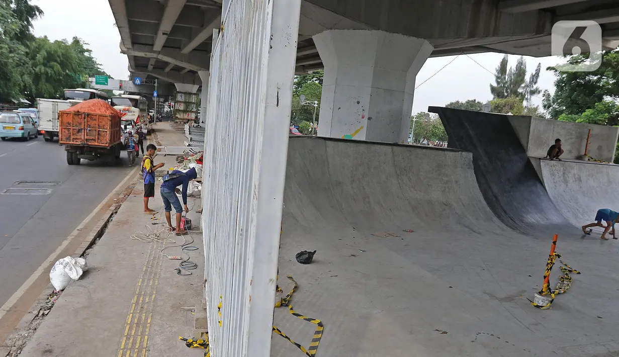 Pekerja menyelesaikan pembangunan Skate Park kolong Flyover Pasar Rebo, Jakarta, Selasa (10/12/2019). Skatepark yang ditargetkan rampung pada akhir November 2019 tersebut hingga kini belum dapat digunakan kerena masih ada beberapa pembangunan yang belum rampung. (Liputan6.com/Herman Zakharia)