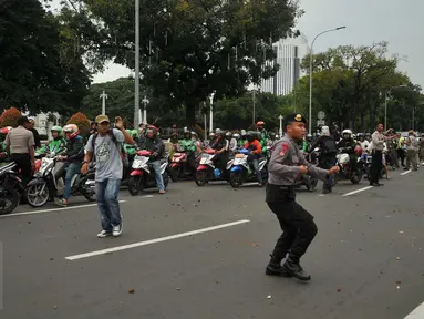 Pengemudi ojek online dilempari batu oleh sopir taksi yang melakukan unjuk rasa di depan Istana Negara, Jakarta, Selasa (22/3). Aksi itu pecah saat pengunjuk rasa mendapat ejekan dari pengemudi ojek online. (Liputan6.com/Gempur M Surya)