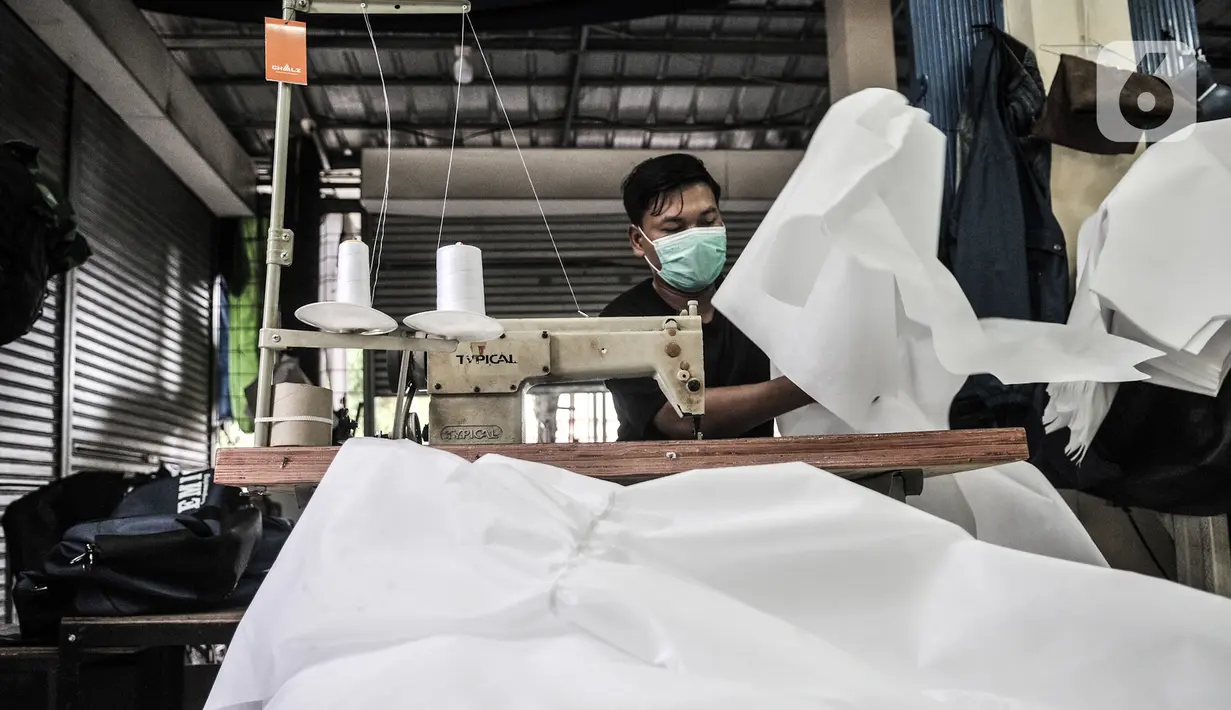 Pekerja menyelesaikan pembuatan baju hazmat di salah satu industri konveksi Pusat Industri Kecil (PIK), Jakarta, Rabu (30/12/2020). Baju hazmat dijual dengan harga Rp 65 ribu-Rp 195 ribu per buah, tergantung jenis bahan. (merdeka.com/Iqbal S. Nugroho)