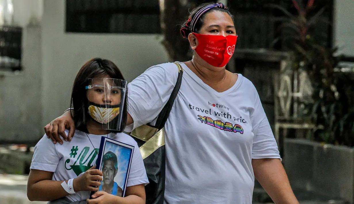 Seorang anak perempuan membawa foto kerabatnya di tempat pemakaman di Manila, Filipina, 28 Oktober 2020. Pemerintah Filipina memerintahkan tempat pemakaman ditutup demi mencegah pertemuan massal dan penyebaran COVID-19 saat peringatan Hari Arwah dan Hari Raya Orang Kudus. (Xinhua/Rouelle Umali)