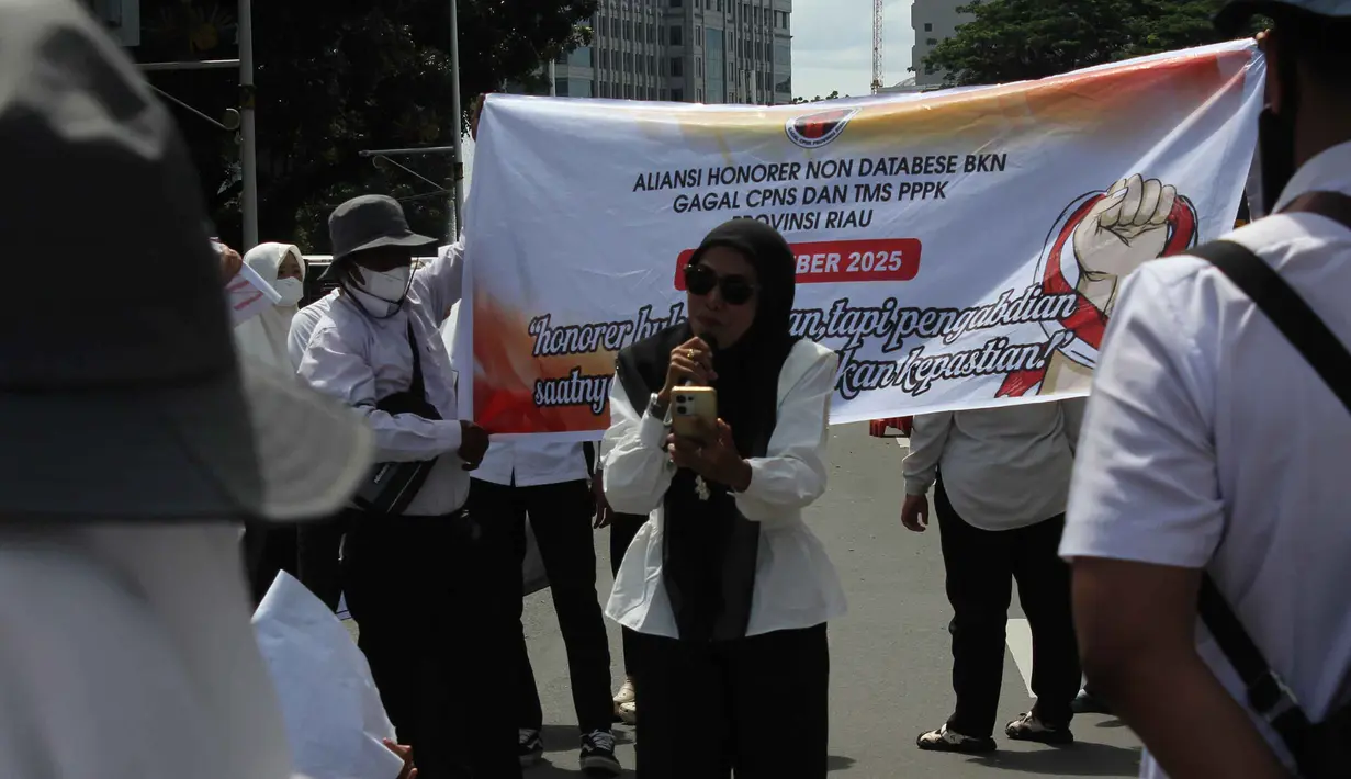 Aksi ini merupakan bentuk protes terhadap diskriminasi dalam seleksi CASN/PPPK 2024, ketiadaan aturan yang menjamin keberlanjutan status kerja, serta ancaman Pemutusan Hubungan Kerja (PHK) dan peralihan ke sistem outsourcing yang semakin meluas. Tampak dalam foto, massa dari Aliansi Honorer Non Database BKN Gagal Calon Pegawai Negeri Sipil (CPNS) Indonesia saat menggelar Aksi Damai Jilid 2 Nasional di kawasan Silang Selatan Monumen Nasional, Jakarta Pusat, pada Senin (17/11/2025). (merdeka.com/magang/Rendi Saputra)