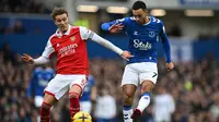 Gelandang Arsenal, Martin Odegaard, berduel dengan gelandang Everton, Dwight McNeil pada pertandingan pekan ke-22 Premier League 2022/2023 yang digelar di Goodison Park, Sabtu (4/2/2023) malam WIB. (AFP/Paul Ellis)