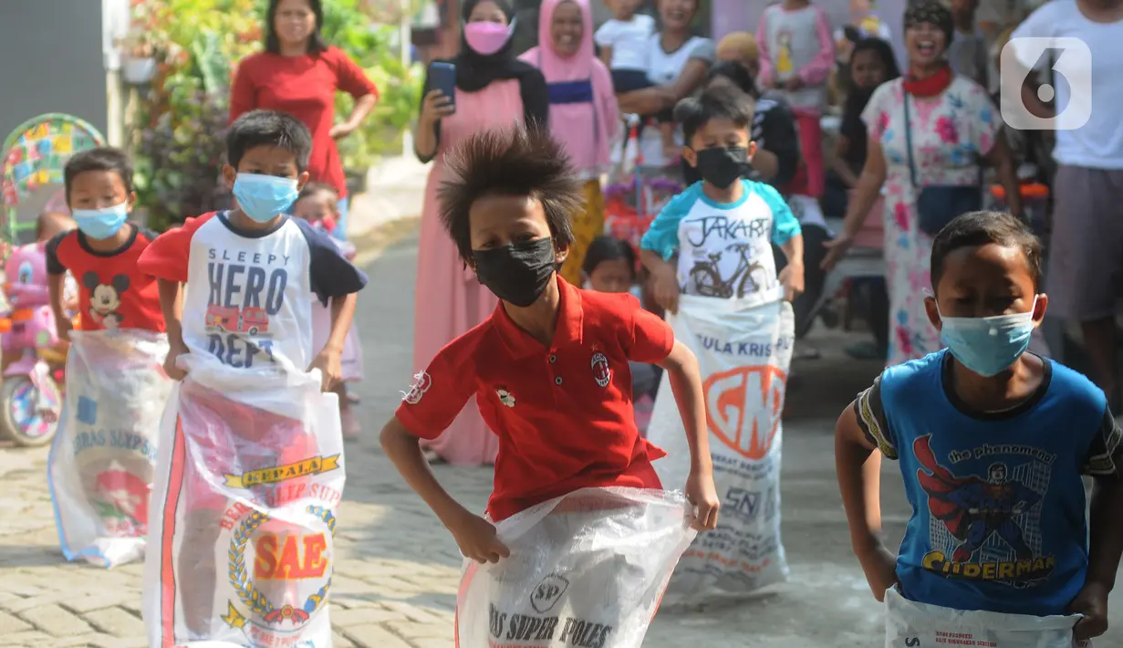 Anak-anak saat mengikuti lomba balap karung peringatan HUT Kemerdekaan ke-76 RI di Benda Baru, Pamulang, Tangsel, Selasa (17/8/2021). Di sejumlah kawasan pinggiran Jabotabek warga tetap melaksanakan peringatan HUT kemerdekaaan RI walau masih dalam status PPKM Level 4. (merdeka.com/Arie Basuki)