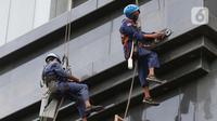 Aktivitas pekerja ketinggian di salah satu bagian gedung Pengadilan Negeri Jakarta Pusat, Rabu (18/11/2020). Berdasarkan data BP Jamsostek, angka klaim kecelakaan kerja semester I 2020 meningkat 128% dari periode yang sama 2019, dari 85.109 kasus menjadi 108.573. (Liputan6.com/Helmi Fithriansyah)