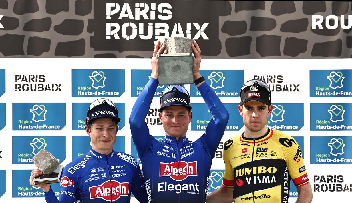 Pebalap Alpecin-Deceuninck, Mathieu Van der Poel (tengah) merayakan kemenangan saat ajang balap sepeda Paris Roubaix 2023 yang menempuh Compiegne hingga Roubaix, Prancis utara, 9 April 2023. (AFP/Francois Lo Presti)
