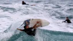 Aksi seorang peserta menaklukan ombak selama mengikuti dalam kompetisi surfing di laut Mediterania di Ashdod, Israel, (17/11). (REUTERS/Amir Cohen)