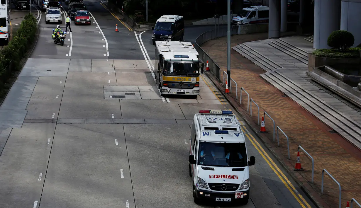 Polisi lalu lintas memblokir jalan saat iring-iringan mobil tahanan membawa terdakwa Rurik Jutting ke Pengadilan Tinggi Hong Kong, Selasa (25/10). (Reuters/Bobby Yip)