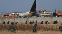 Pesawat Jeju Air berjenis Boeing 737-800 jatuh dan terbakar di Bandara Internasional Muan di Provinsi Jeolla Selatan, sekitar 288 kilometer sebelah barat daya Seoul pada tanggal 29 Desember 2024. (JUNG YEON-JE/AFP)