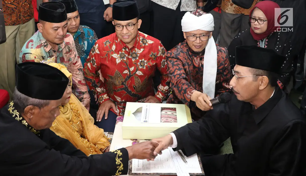Gubernur DKI Jakarta, Anies Baswedan dan Abdullah Gymnastiar menjadi saksi pernikahan pasangan tertua dalam nikah massal dan isbat nikah pada malam pergantian tahun 2018-2019 di Jakarta, Senin (31/12). Liputan6.com/Helmi Fithriansyah)