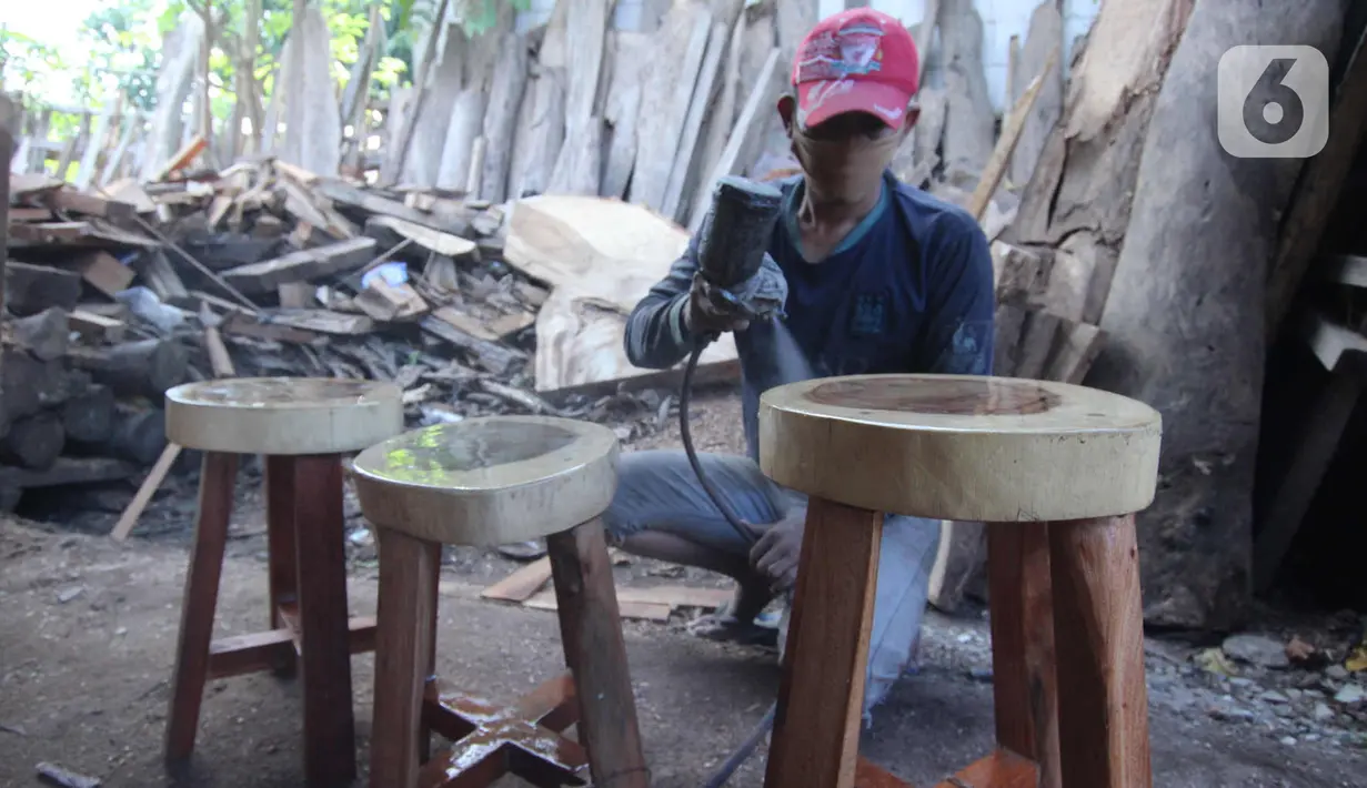 Perajin menyelesaikan pembuatan kursi dari kayu bekas di Pinang, Kota Tangerang, Banten, Minggu (28/3/2021). Furnitur berbahan dasar kayu bekas tersebut dijual dari harga Rp50.000 hingga lima juta rupiah dan dipasarkan hingga ke Sumatera dan Kalimantan. (Liputan6.com/Angga Yuniar)
