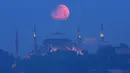 Bulan purnama terlihat di atas Haghia Sophia yang ikonik di Istanbul, Turki, Senin (16/5/2022) dini hari. (AP Photo/Mucahid Yapici)
