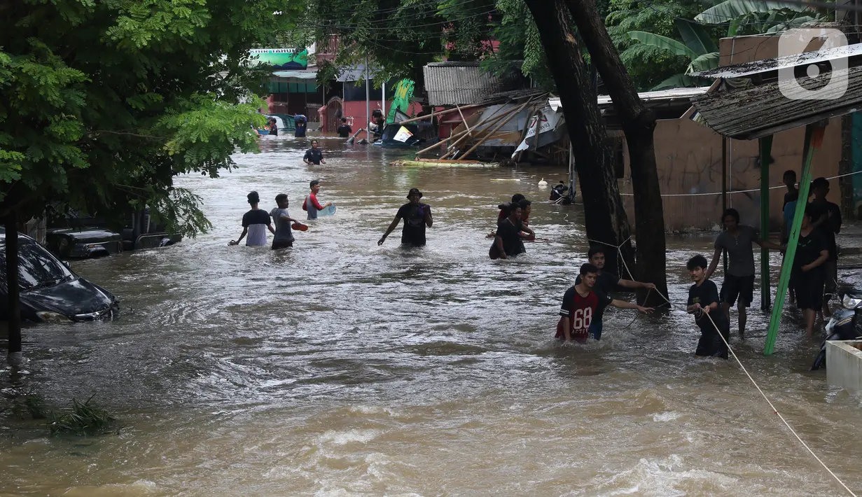 Warga berusaha melintasi banjir yang merendam perumahan Ciledug Indah, Tangerang, Banten, Kamis (2/1/2020). Memasuki hari kedua, kondisi perumahan tersebut masih tergenang banjir setinggi dada orang dewasa. (Liputan6.com/Angga Yuniar)