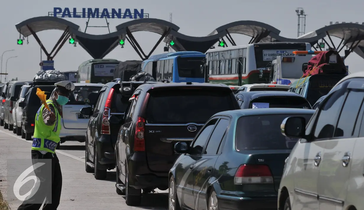 Petugas Kepolisian saat mengatur kendaraan yang masuk ke gerbang Tol Palimanan, Jawa Barat, Selasa (14/7/2015). Hingga H-3 jelang lebaran 2015 pemudik sudah mulai memadati tol Cipali. (Liputan6.com/Herman Zakharia)