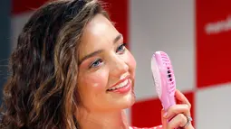 Model Miranda Kerr menggunakan kipas angin kecil selama acara promosi kuliner di Tokyo, Jepang, (10/7). Miranda Kerr tampil cantik dengan dress merah saat mempromosikan salah satu kuliner di Tokyo. (AP Photo/Shizuo Kambayashi)