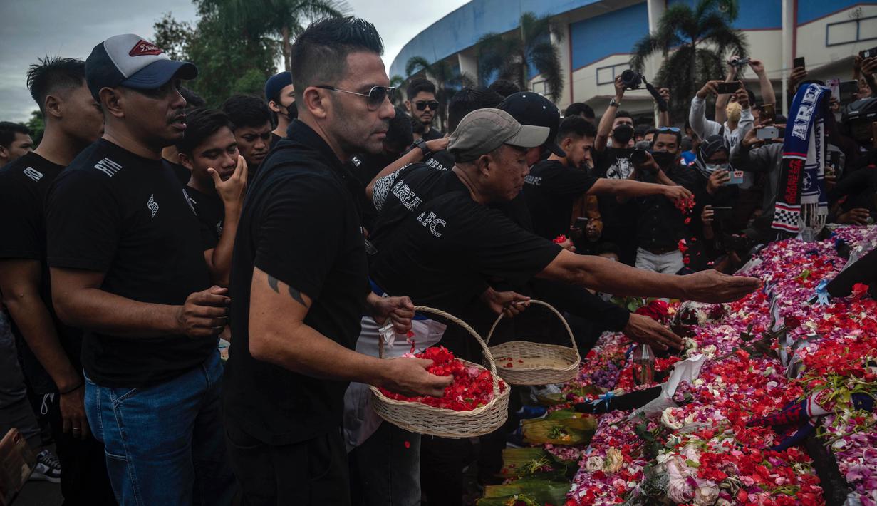 Pelatih Arema FC, Javier Roca melakukan tabur bunga di Tugu Singa Stadion Kanjuruhan. (AFP/Juni Kriswanto)