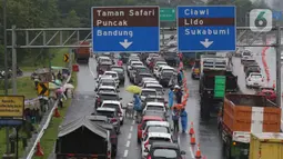 Sejumlah kendaraan berhenti di jalan tol Jagorawi menanti waktu buka tutup jalur menuju kawasan wisata puncak, Bogor, Jawa Barat, Sabtu (31/10/2020). Akhir pekan beriringan dengan libur panjang dimanfaatkan warga untuk mengunjungi lokasi-lokasi wiisata. (Liputan6.com/Helmi Fithriansyah)