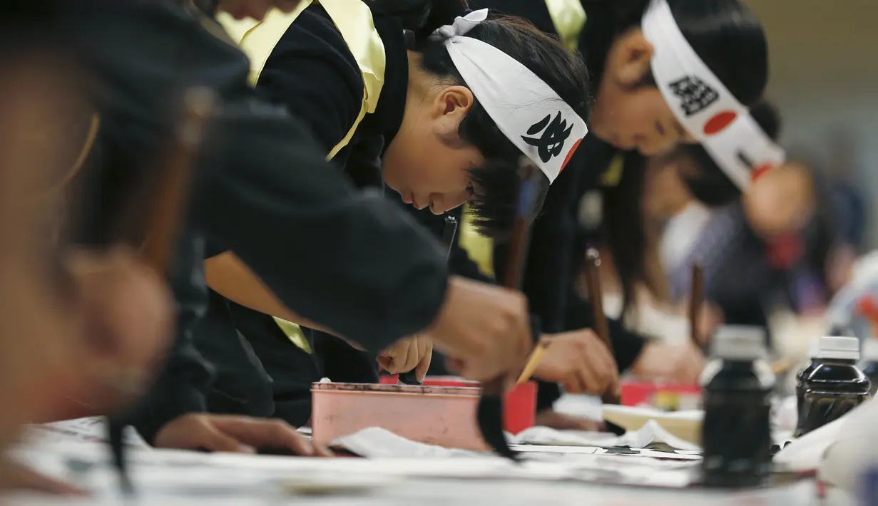Sejumlah peserta ikut ambil bagian saat kontes kaligrafi dalam merayakan tahun baru di Tokyo, Jepang, Selasa (5/1/2016). Lebih dari 3000 peserta menuliskan resolusi tahun baru di atas sebuah kanvas. (REUTERS / Thomas Peter)