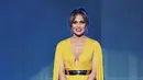 Ceria dalam kuning, Jennifer Lopez memakai gaun Michael Costello dengan potongan leher yang rendah serta sabuk emas yang melingkar di pinggangnya. (AFP/Bintang.com)