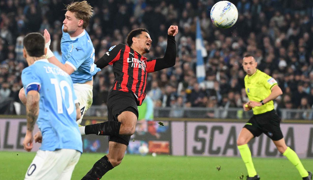 Bek AC Milan asal Swiss, Zachary Athekame (tengah) berebut bola dengan penyerang Lazio asal Denmark, Gustav Isaksen (kedua kiri) selama pertandingan pekan ke-29 Serie A Italia 2025/2026 di Olimpico Stadium, Roma, Minggu 15 Maret 2026 waktu setempat atau Senin (16/3/2026) dini hari WIB. Peluang AC Milan memangkas jarak dengan Inter Milan di klasemen Serie A 2025/2026 kandas. (Alberto PIZZOLI/AFP)