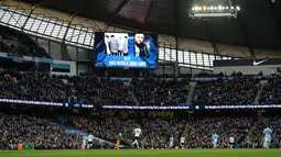 Sebuah layar menampilkan foto para anggota band  Viola Beach dan manajer mereka menjelang laga Manchester City dan Tottenham Hotspur di Inggris, Minggu (14/2). Empat personel band asal Inggris itu tewas dalam kecelakaan mobil di Swedia. (Oli SCARFF/AFP)