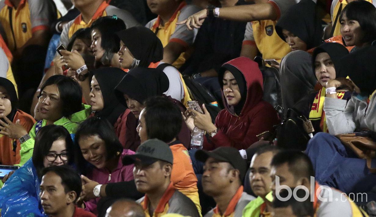 Tidak hanya sebagai pendukung Bhayangkara FC, Polwan  juga sibuk update kegiatan mereka di media sosial saat timnya melawan Semen Padang pada babak delapan besar Piala Presiden 2017 di Stadion Manahan, Solo, (26/2/2017). (Bola.com/Nicklas Hanoatubun) 