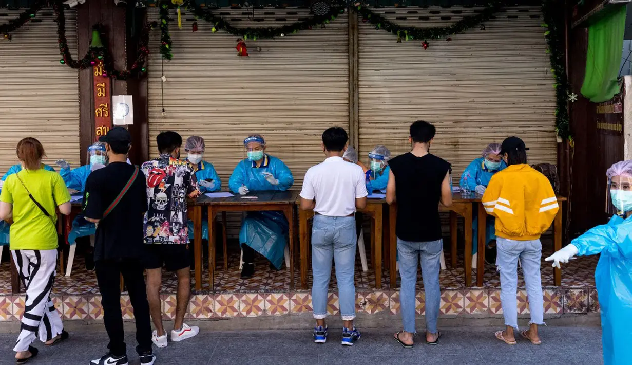Petugas medis mengambil rincian data dari pekerja perhotelan dan pariwisata saat tes virus corona COVID-19 di Jalan Khao San, Bangkok, Thailand, Kamis (6/1/2022). (Jack TAYLOR/AFP)