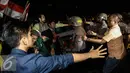 Aksi saling dorong antara massa dengan polisi saat unjuk rasa di depan Istana Negara, Kamis (12/1). Aksi sejenis dilakukan serentak di 19 titik kota berbeda di Indonesia. (Liputan6.com/Faizal Fanani)