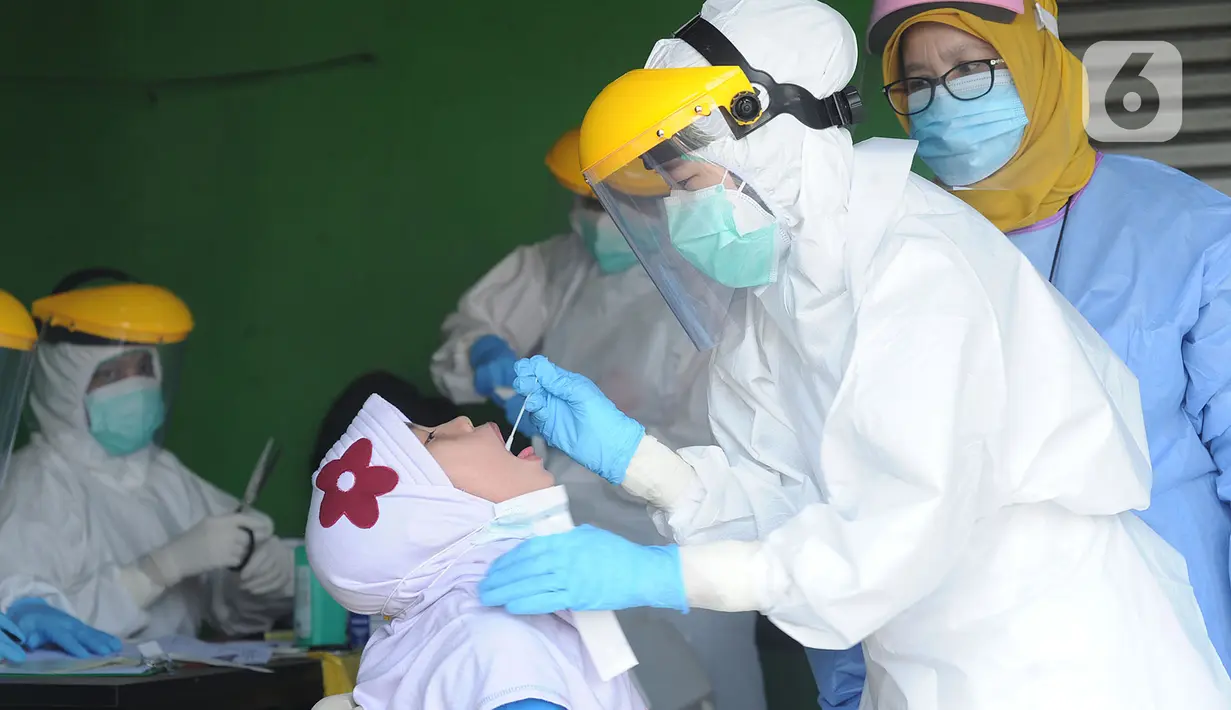 Petugas medis dari Pemkot Jakarta Selatan melakukan tes swab Covid-19 para pedagang  di Pasar Sayur Cipulir, Jakarta Selatan, Kamis (25/6/2020). Kegiatan yang dilakukan kepada puluhan pedagang dan warga seputar pasar ini dalam rangka memutus mata rantai penyebaran Covid-19. (merdeka.com/Arie Basuki)