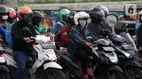 Pengendara motor di pemberhentian lampu Merah, Kota Depok, Jawa Barat, Minggu (12/4/2020). Menteri Kesehatan menyetujui menerapkan Pembatasan Sosial Berskala Besar (PSBB) di wilayah Kota Depok yang akan dimulai, Rabu (15/4) dalam pencegahan meluasnya COVID-19. (Liputan6.com/Helmi Fithriansyah)